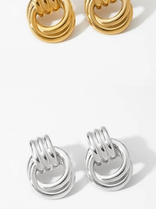 Macro detail of high-polish mixed metal earrings with ribbed texture and double hoops