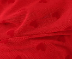 Gros plan sur tissu en maille rouge avec motifs de cœurs texturés et tissage fin