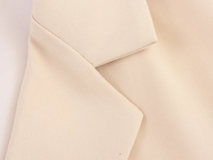 Macro detail of elegant beige blazer notched lapel showcasing twill fabric texture