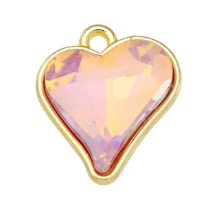 Detail of pink crystal heart pendant with faceted finish and golden alloy edge on white