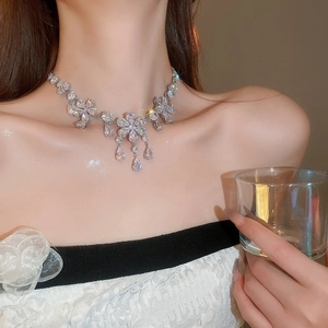 Close-up of elegant silver necklace with flower drop pendants and sparkling crystals