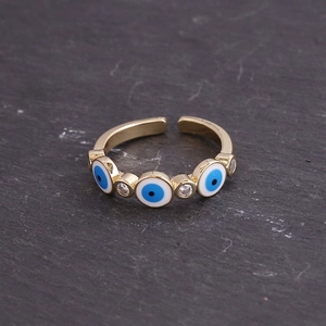 Detail of gold evil eye rings with blue cubic zirconia and adjustable open band style
