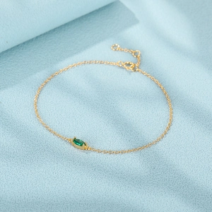 Detail of gold chain bracelet with emerald marquise gemstone and adjustable clasp