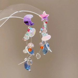 Detail of asymmetric chiffon flower earrings with purple moon and pink star charms