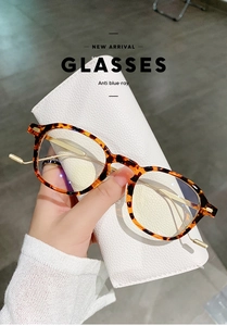 Detail showing retro tortoiseshell frame glasses with gold temples on leather case