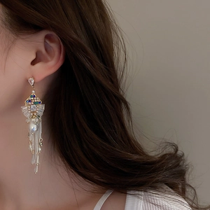 Close-up of bohemian tassel earrings with rhinestones, colorful gems and pearl detail