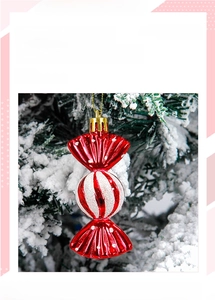 Detail view of a shiny red Christmas candy ornament with white glitter stripes on a tree
