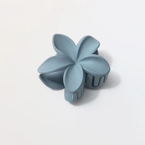 Macro view of matte grey-blue frangipani hair claw clip with 8cm frosted petals