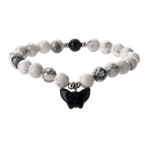 White marble bead bracelet with dark blue goldstone and butterfly charm on white background