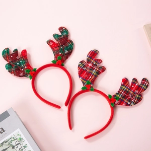 Détail d'un serre-tête bois de renne de Noël avec tissu à carreaux rouges et baies festives