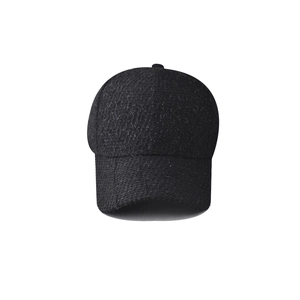 Dettaglio ravvicinato della trama spessa in tweed nero e del tessuto della basecap