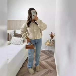 Gilet beige en maille épaisse avec boutons présenté dans un style de tenue d'intérieur