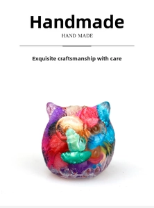 Close-up of handmade resin owl statue with colorful crystal gravel and artistic texture