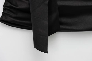 Macro detail of glossy black satin fabric showing smooth texture and light reflection