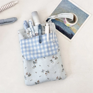 Detail view of floral and plaid nurse pouch with dual-layer pockets for pens