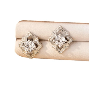 Vintage silver floral studs with sparkling round zircon on a leather display stand