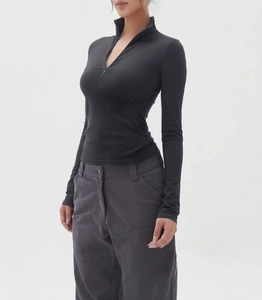 Detail of black slim-fit half-zip athletic top paired with grey cargo trousers