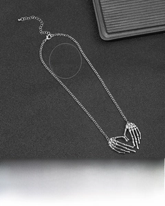 Detail of silver alloy skeleton hand heart pendant with gothic hip hop style chain necklace
