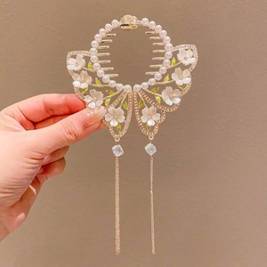 Détail de la pince à cheveux muguet avec perles, pétales floraux et longues franges en métal