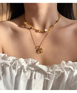 Detail of 18k gold plated double necklace with pony pendant and white shell inlay