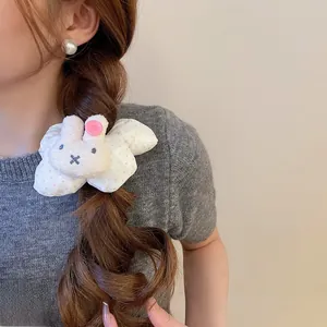 Detailed close-up of a white polka dot hair tie with a 3D plush rabbit head