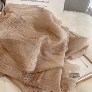 Close-up of silk wool scarf showing metallic gold stripes and fine mesh texture