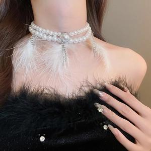 Detail of double-layer pearl choker with white feather tassels and crystal fringe