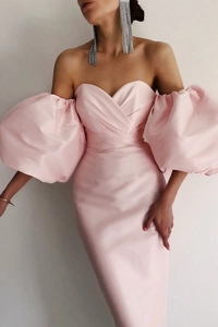 Detail of elegant pink satin off-shoulder dress with voluminous puff sleeves and silky texture