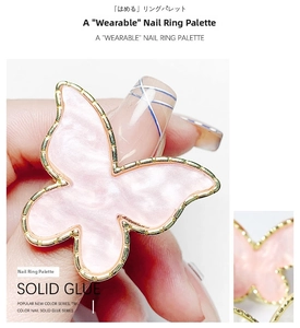 Macro view of butterfly nail art palette ring with pink marble texture and gold trim