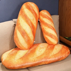 Drei Größen realistischer Baguette-Plüschkissen auf einem gemütlichen Sofa