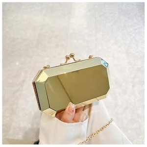Macro shot of a golden geometric faceted evening clutch with a sphere clasp and chain