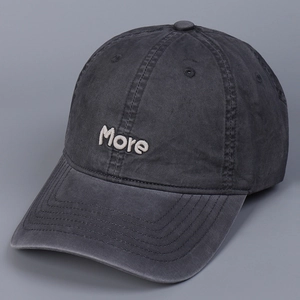 Close-up of charcoal grey cotton baseball cap with cream 'More' letter embroidery