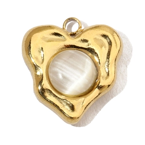 Close-up of heart-shaped gold steel pendant featuring a round white cat-eye stone inlay