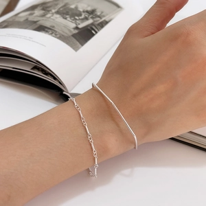 Close-up of minimalist S925 sterling silver twisted chain and slim bar bracelet set