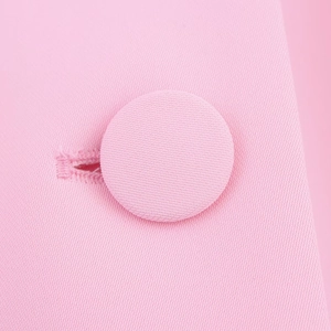 Gros plan sur la texture en sergé rose et le bouton recouvert assorti d'un blazer