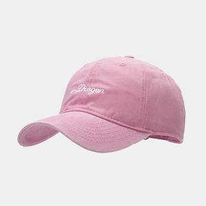 Detail shot of pink cotton baseball cap with white cursive Dragon embroidery on front