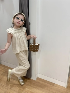 Close-up of girls beige sleeveless ruffled top and matching pants in linen fabric