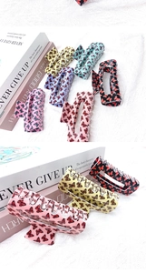 Détail des pinces à cheveux papillon multicolores avec des motifs vifs sur tissu texturé