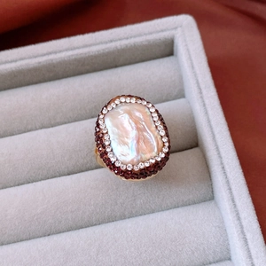 Macro shot of vintage baroque ring with iridescent pearl and purple crystals in a box