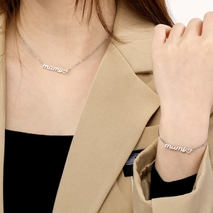 Silver Mami necklace and bracelet set with heart detail worn by a model
