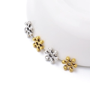 Macro shot of 7mm snowflake spacers in gold and silver metal finishes for DIY bracelets