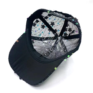 Internal detail of black mesh baseball cap with floral prints and colorful sequins