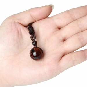 Pendentif vintage en œil de tigre naturel 16mm avec cordon tressé tenu à la main