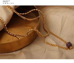 Detailed shot of vintage gold chain necklace with square agate pendant on silk fabric