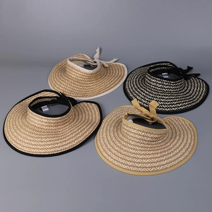 Flat lay view of four foldable straw visors with elegant bows in various colors