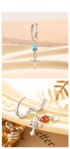 Detail showing cross pendant earrings with small inlaid diamonds and marquise gemstones