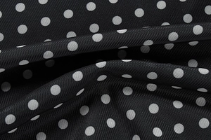 Macro detail of high-quality black and white polka dot mesh fabric with soft drape texture