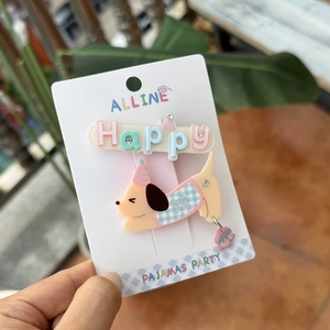 Close-up of acrylic Happy letter hair clip and cute dog hairpin on a display card