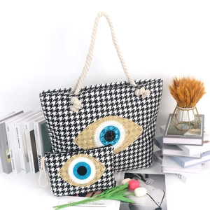 Close-up of houndstooth beach bag set with evil eye embroidery and rope handles