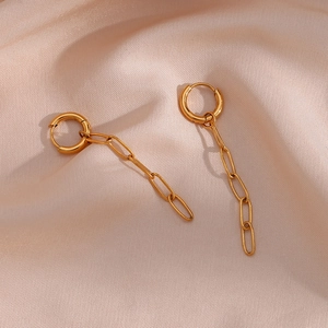 Detail shot of long 18K gold-plated paperclip chain earrings on champagne silk fabric